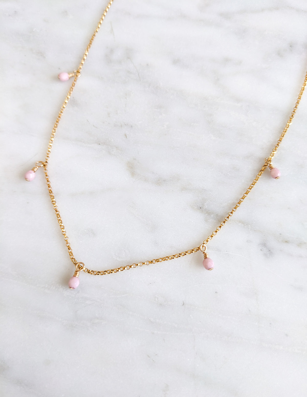 Collier Rosie à petites perles de verre tchèque roses suspendues à une chaîne en gold filled 14k.