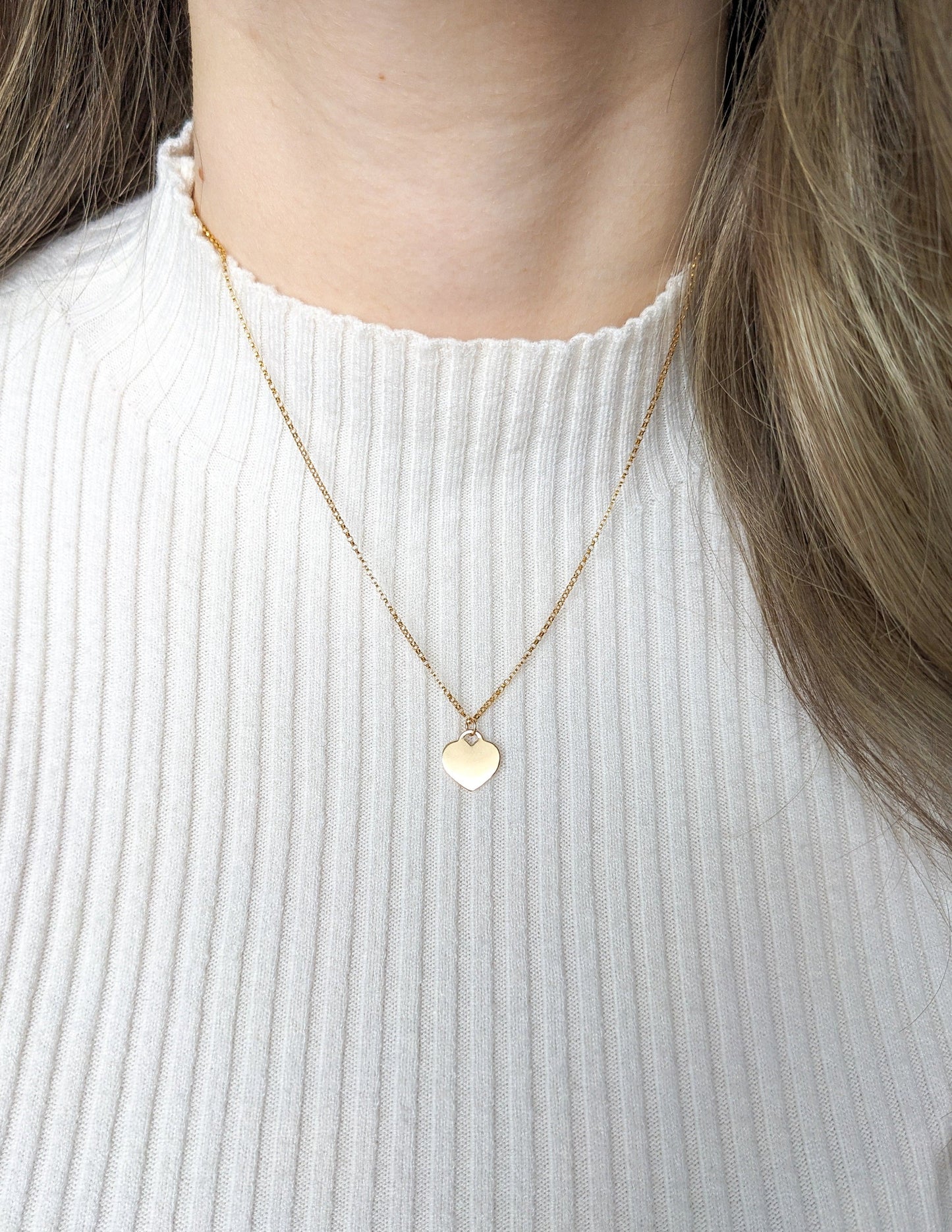 Collier Cœur en gold filled 14k porté sur un chandail blanc côtelé.