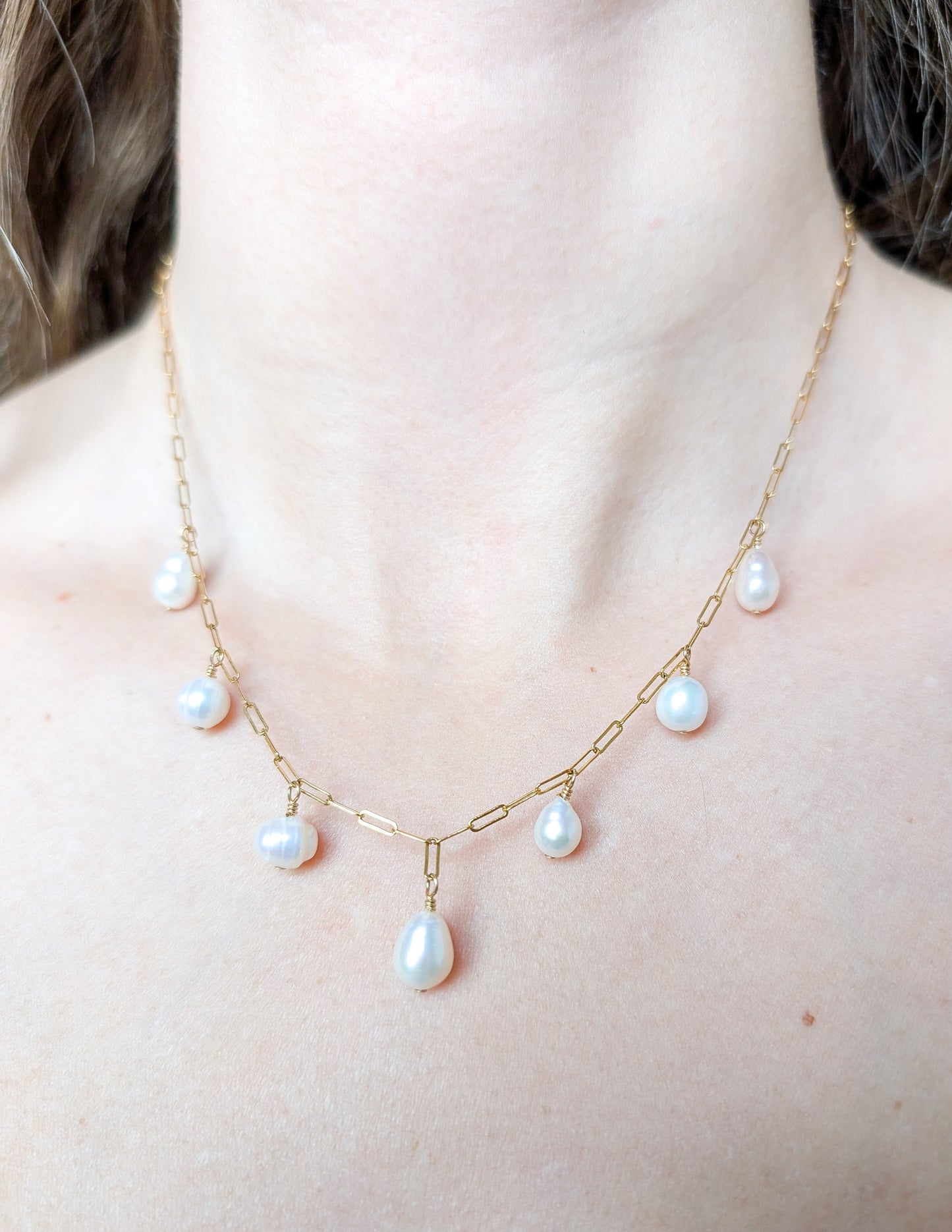 Collier Cascade porté au cou, avec chaîne paperclip en gold filled 14k et perles d’eau douce suspendues.