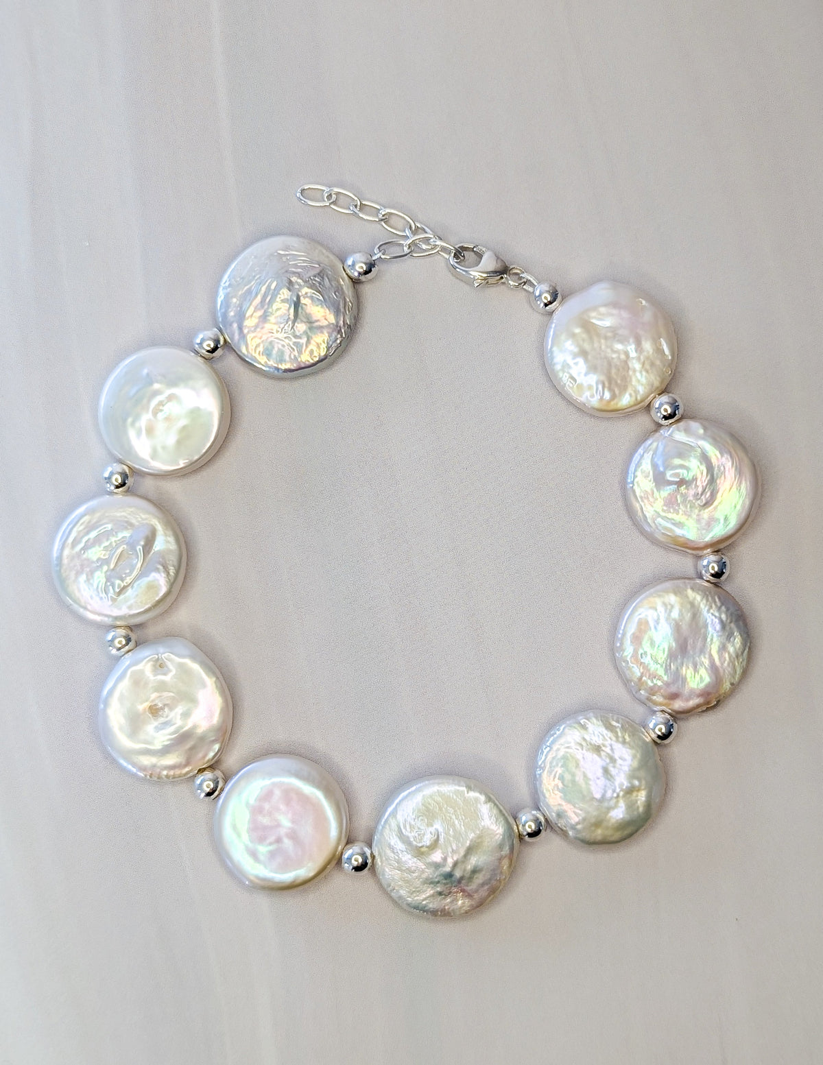 Bracelet Irisé présenté en cercle, avec perles d’eau douce iridescentes et fermoir en argent sterling 925.
