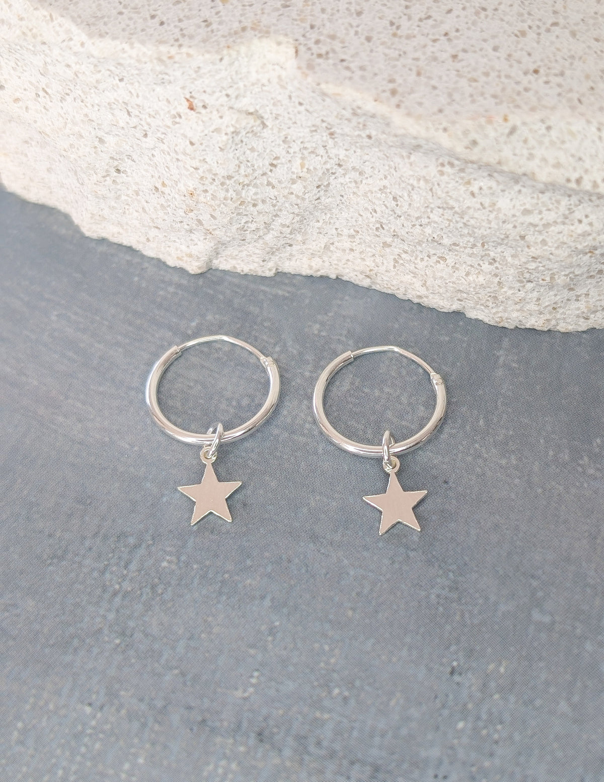 Paire d’anneaux Étoile en argent sterling 925, présentée à plat avec ses pendentifs.