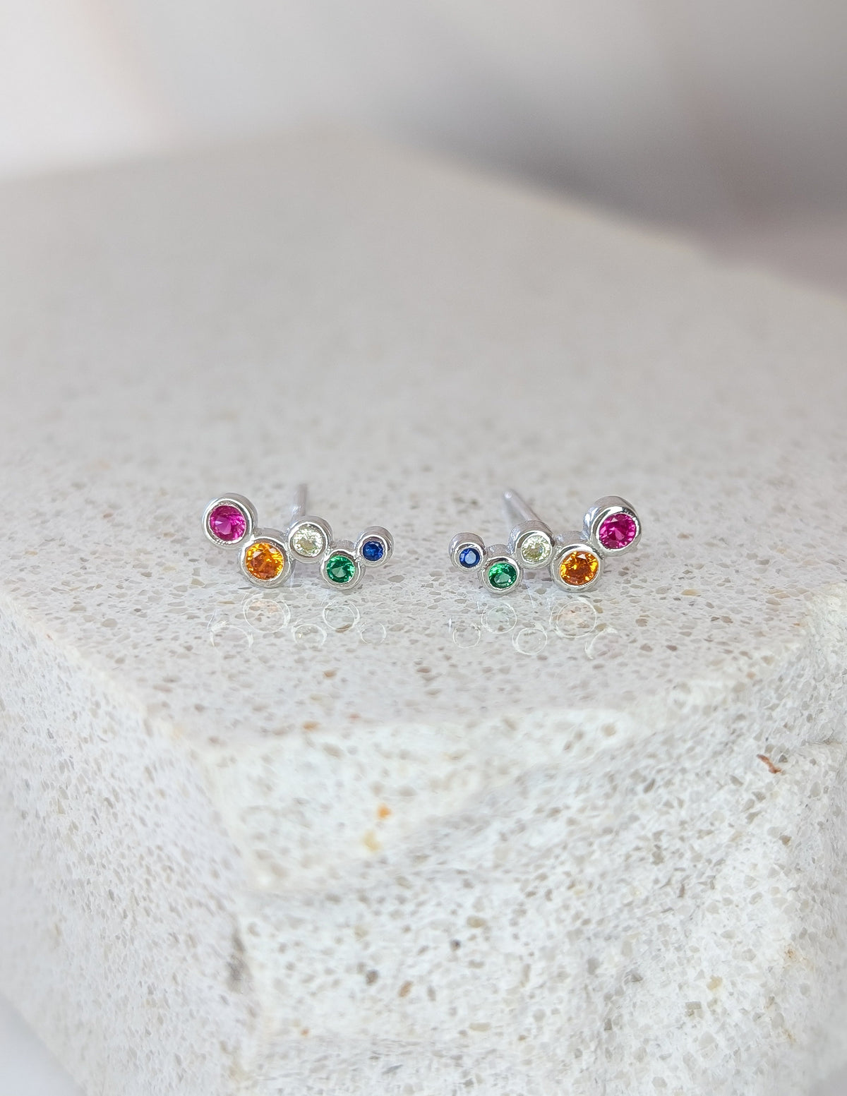 Boucles d’oreilles Luma en argent sterling 925, avec une rangée courbée de zircons colorés.