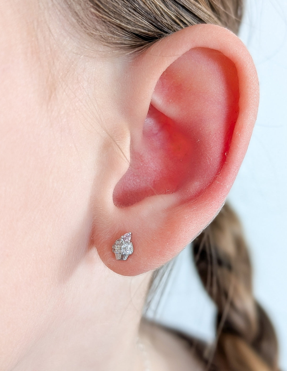 Boucle d’oreille Cupcake pour enfant en argent sterling 925 et zircons, portée au lobe.