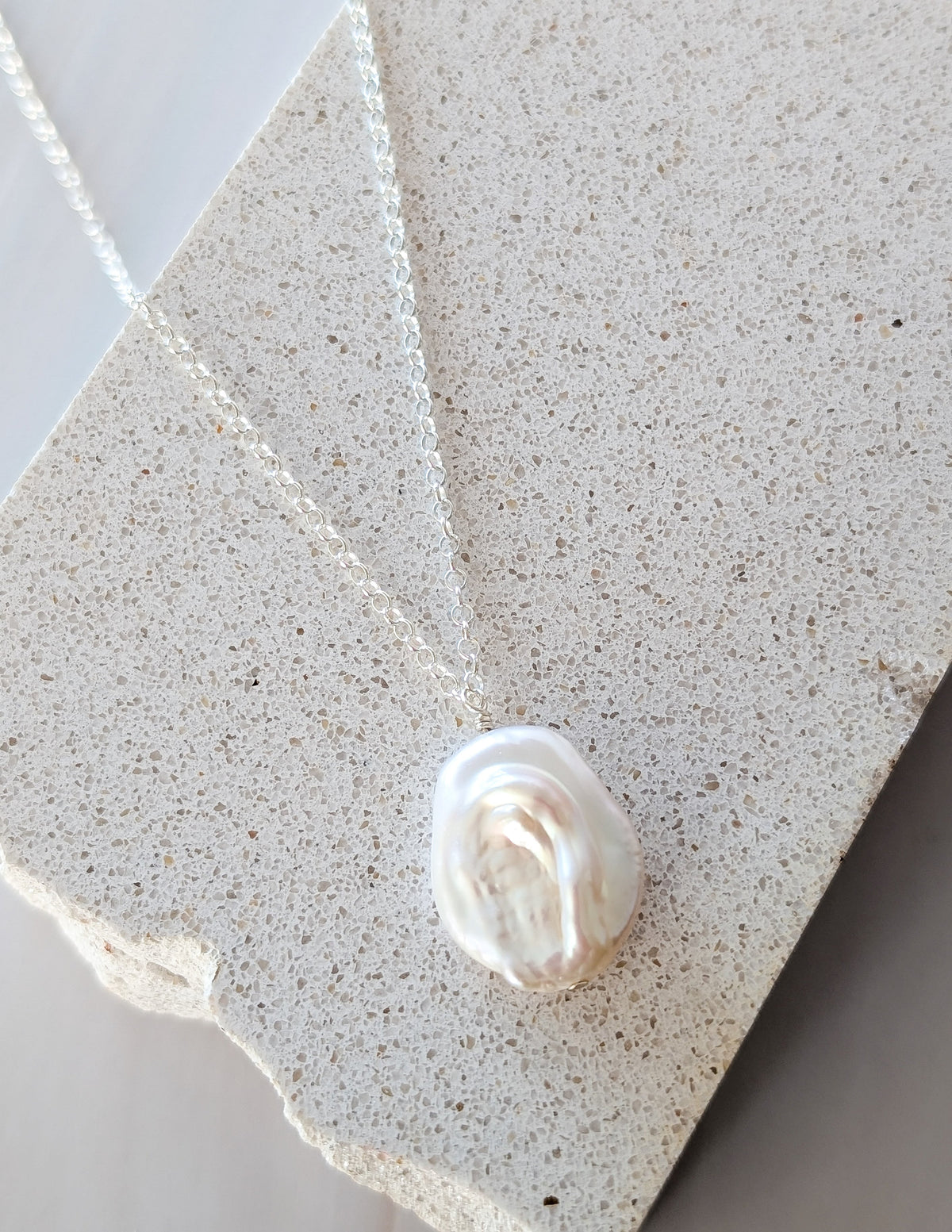 Collier Baroque en argent sterling 925, avec gros pendentif en perle d’eau douce sur une pierre claire.