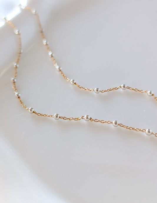 Détail de la chaîne bicolore du Collier Duo avec petites perles argentées et maillons dorés.